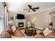Inviting living room featuring a fireplace, ceiling fan, and comfortable leather sofa at 8962 Landsdowne Ave, Harrisburg, NC 28075