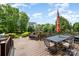 Inviting outdoor deck with dining and outdoor fireplace overlooking the lush backyard at 8962 Landsdowne Ave, Harrisburg, NC 28075