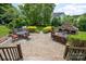 Spacious outdoor patio with a charming stone fireplace and comfortable seating arrangement for entertaining at 8962 Landsdowne Ave, Harrisburg, NC 28075