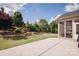 Backyard featuring a stone retaining wall, landscaped garden beds, and a well-manicured lawn at 9026 Raven Top Dr, Mint Hill, NC 28227