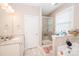 Well-lit bathroom with double vanity, soaking tub, glass shower, and neutral color palette at 9026 Raven Top Dr, Mint Hill, NC 28227