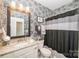 Stylish bathroom with black and white floral wallpaper, granite vanity, and shower with curtain at 9026 Raven Top Dr, Mint Hill, NC 28227