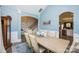 Formal dining room featuring light wood table, decorative rug, and archway to staircase and kitchen at 9026 Raven Top Dr, Mint Hill, NC 28227