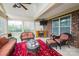 Inviting sunroom with comfortable wicker seating and a cozy fireplace, bathed in natural light at 9026 Raven Top Dr, Mint Hill, NC 28227