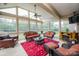 Sunroom filled with natural light, comfortable wicker furniture, and a decorative fireplace at 9026 Raven Top Dr, Mint Hill, NC 28227
