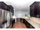 Modern kitchen with granite countertops, stainless steel appliances, and dark cabinetry at 9614 Springholm Dr, Charlotte, NC 28278