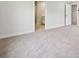 Spacious carpeted bedroom showcasing neutral tones, and a doorway leading to the adjoining bathroom at 9944 Manor Vista Trl, Kannapolis, NC 28027
