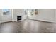Cozy living room with wood-look flooring, a fireplace, and large windows providing ample light at 9944 Manor Vista Trl, Kannapolis, NC 28027