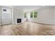 Light-filled living room featuring a fireplace with marble surround and hardwood floors at 9944 Manor Vista Trl, Kannapolis, NC 28027