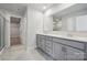 A modern bathroom with gray cabinets, a large mirror, and a double sink at 9956 Manor Vista Trl, Kannapolis, NC 28027