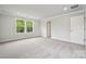 A spacious bedroom with neutral carpeting, baseboard trim, and two entry doors at 9956 Manor Vista Trl, Kannapolis, NC 28027