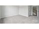 A cozy bedroom featuring neutral carpeting, baseboard trim, and an open doorway to the staircase at 9956 Manor Vista Trl, Kannapolis, NC 28027