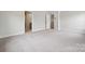 A spacious bedroom with neutral carpeting, baseboard trim, and two entry doors at 9956 Manor Vista Trl, Kannapolis, NC 28027