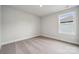 A cozy bedroom featuring neutral carpeting, baseboard trim, and a window at 9956 Manor Vista Trl, Kannapolis, NC 28027