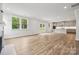 Open-concept living and kitchen area featuring wood-look floors, recessed lights, and windows with natural light at 9956 Manor Vista Trl, Kannapolis, NC 28027