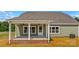 Covered back porch with white columns, ceiling fans, brick base, and an access door to the backyard at Lot 101 Coppergate Dr, Salisbury, NC 28147