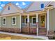 Charming home showcasing a welcoming front porch with brick accents and well-maintained landscaping at Lot 101 Coppergate Dr, Salisbury, NC 28147