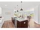 The kitchen island with seating and stainless steel appliances opens to the living and dining areas at Lot 101 Coppergate Dr, Salisbury, NC 28147