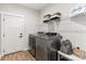 Convenient laundry room featuring modern washer and dryer, storage shelf and a stylish interior door at Lot 101 Coppergate Dr, Salisbury, NC 28147