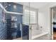 Well-lit bathroom featuring updated shower with blue tile, tub, and shower niche at 100 Brookstone Dr, Mount Holly, NC 28120