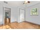 Bright bedroom with wood-look floors, a double closet, and a door to another room at 100 Brookstone Dr, Mount Holly, NC 28120