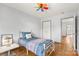 Bright bedroom with a bed, wood-look floors, and a door leading to another room at 100 Brookstone Dr, Mount Holly, NC 28120
