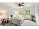 Well-lit bedroom with two windows, neutral carpeting, and a ceiling fan at 100 Brookstone Dr, Mount Holly, NC 28120