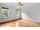 Bright bedroom featuring hardwood floors, two windows, and a ceiling fan for added comfort at 100 Brookstone Dr, Mount Holly, NC 28120