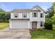 Charming two-story home with a two car garage, neutral siding, and well manicured landscaping at 100 Brookstone Dr, Mount Holly, NC 28120