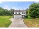 Two-story home with a two-car garage, neutral siding, and a long concrete driveway at 100 Brookstone Dr, Mount Holly, NC 28120