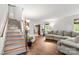 Bright living room featuring wood flooring, a fireplace, staircase and plenty of natural light at 100 Brookstone Dr, Mount Holly, NC 28120