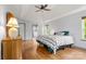 Bright main bedroom features wood floors, ceiling fan, and ensuite bathroom access at 100 Brookstone Dr, Mount Holly, NC 28120