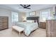 Bedroom featuring a tufted headboard, ceiling fan, and neutral tones, creating a serene and inviting space at 10016 Tealridge Ln, Charlotte, NC 28277