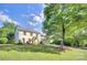 Beautiful white painted brick home with a sprawling green lawn and mature trees in a peaceful setting at 10016 Tealridge Ln, Charlotte, NC 28277