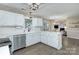 Open kitchen with white cabinets, stainless steel appliances, quartz countertops, and seamless flow to dining area at 10016 Tealridge Ln, Charlotte, NC 28277