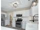 Bright kitchen featuring white cabinetry, stainless steel appliances, quartz countertops, and modern fixtures at 10016 Tealridge Ln, Charlotte, NC 28277