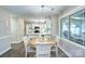 Open concept eat-in kitchen area with white cabinets, island seating, and great natural lighting at 10016 Tealridge Ln, Charlotte, NC 28277
