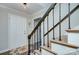 Stylish staircase with black metal railing and stained wood treads leading to the upper level of the home at 10016 Tealridge Ln, Charlotte, NC 28277
