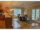 Open dining room with hardwood floors, stylish lighting, and view to outdoor space at 10817 Bere Island Dr, Charlotte, NC 28278