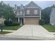 Charming two-story home featuring a stone and siding facade, two-car garage, and manicured lawn at 10817 Bere Island Dr, Charlotte, NC 28278