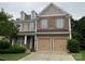 Two-story home showcasing a blend of stone and siding with a two-car garage and well-manicured lawn at 10817 Bere Island Dr, Charlotte, NC 28278