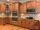 Modern kitchen featuring stainless steel double ovens, granite countertops, and warm wood cabinetry at 10817 Bere Island Dr, Charlotte, NC 28278