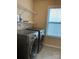 Laundry room with stainless steel washer/dryer, wire shelves, and natural light at 10817 Bere Island Dr, Charlotte, NC 28278