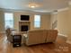 Comfortable living room with a stone fireplace, hardwood floors, and plenty of natural light at 10817 Bere Island Dr, Charlotte, NC 28278