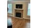 Living room with stone fireplace, mounted television, and hardwood floors, bathed in natural light at 10817 Bere Island Dr, Charlotte, NC 28278