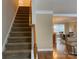Carpeted staircase with wooden railing leads to the upper level of this home at 10817 Bere Island Dr, Charlotte, NC 28278