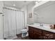 Well-lit bathroom with a shower featuring modern fixtures and a patterned shower curtain at 1108 Stella Ct, Monroe, NC 28110