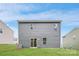 The backyard has a lush green lawn, complemented by a modern gray siding and sliding glass doors at 126 Dorian Pl, Troutman, NC 28166