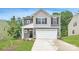 Charming two-story home featuring a stone-accented facade, a two-car garage, and manicured landscaping at 126 Dorian Pl, Troutman, NC 28166