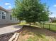 A serene backyard featuring a concrete patio, lush lawn, mature tree, and black metal fencing at 1305 Kings Grove Dr, York, SC 29745